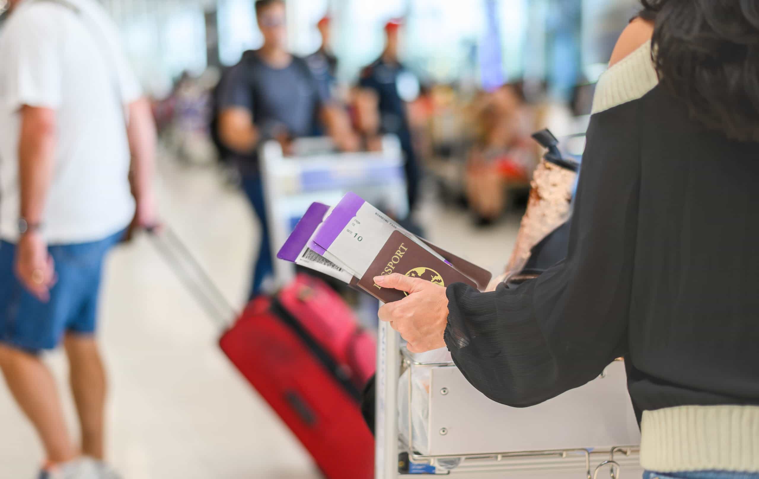 Closeup of girl holding passport and boarding pass at airport