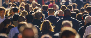 Image of a large crowd of people moving on a city street, viewed from the back
