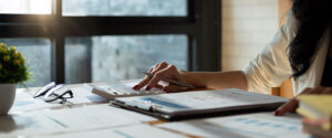 A female accountant works at a desk with a calculator.