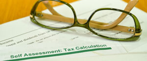 Close up view of the heading on a self assessment tax return calculation form with a pair of glasses